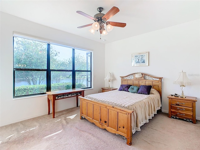 carpeted bedroom featuring ceiling fan and multiple windows