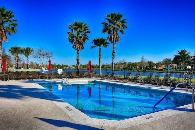 view of swimming pool featuring a water view and a patio area