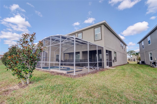 rear view of house featuring a lanai, a yard, a patio, and central AC unit