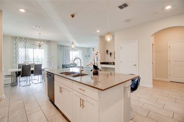 kitchen featuring a kitchen island with sink, sink, pendant lighting, dishwasher, and white cabinetry