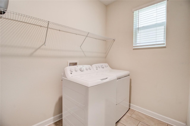 laundry area with washer and dryer and light tile patterned floors