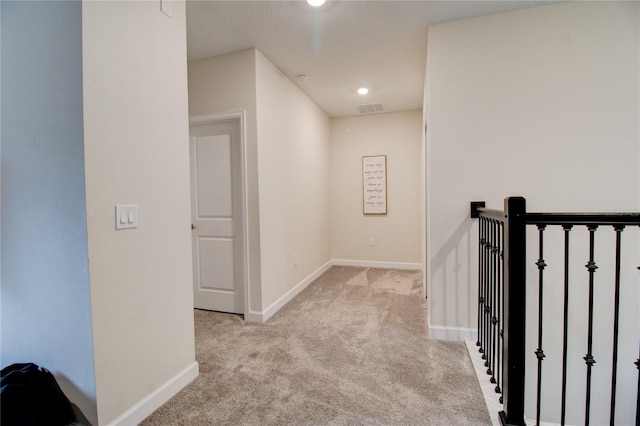 hall featuring light colored carpet