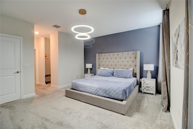 carpeted bedroom with a notable chandelier