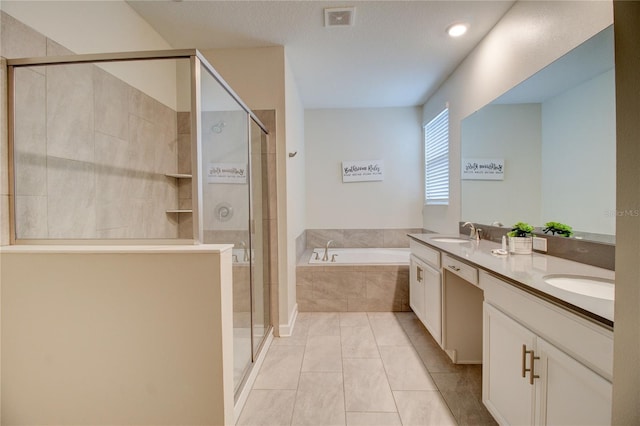 bathroom featuring plus walk in shower, a textured ceiling, vanity, and tile patterned floors