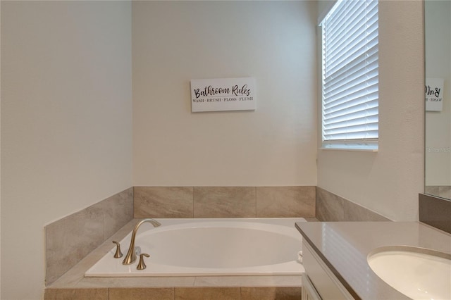 bathroom with vanity and tiled tub