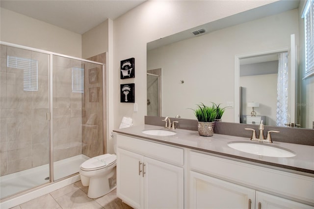 bathroom with tile patterned flooring, vanity, a shower with door, and toilet