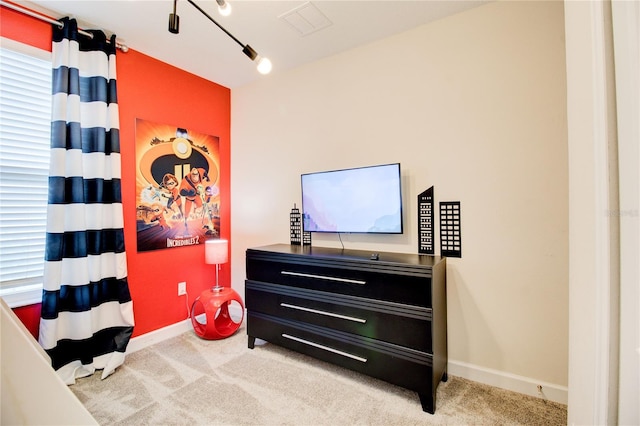 carpeted bedroom with rail lighting