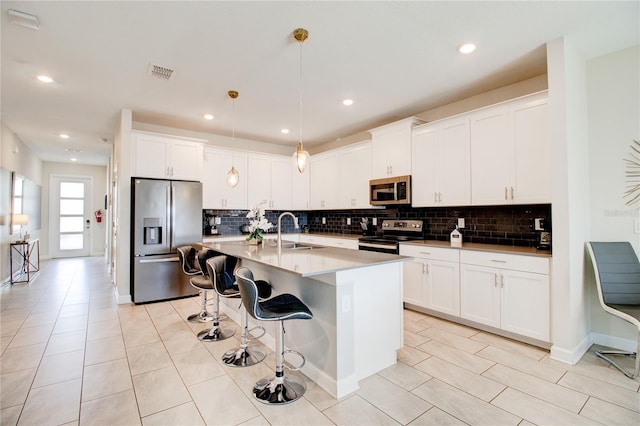 712 Whistling Straits Blvd, Davenport, FL 33896 - kitchen with stainless steel appliances, a sink, decorative backsplash, an island with sink, and recessed lighting