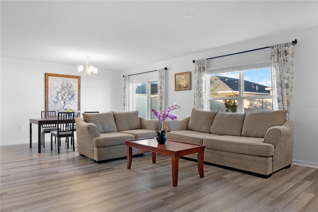 living room with light hardwood / wood-style flooring and a chandelier