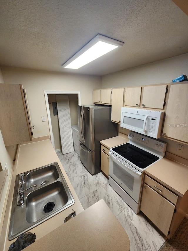 kitchen with sink, white appliances, a textured ceiling, and light brown cabinetry