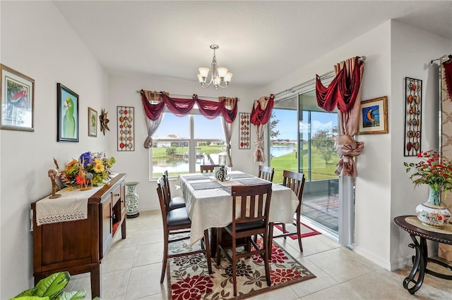 tiled dining space with a water view and a notable chandelier