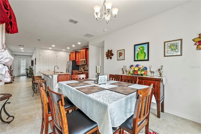 dining area with a chandelier, light tile patterned floors, and sink