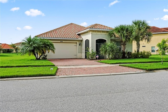 mediterranean / spanish house with a front yard and a garage