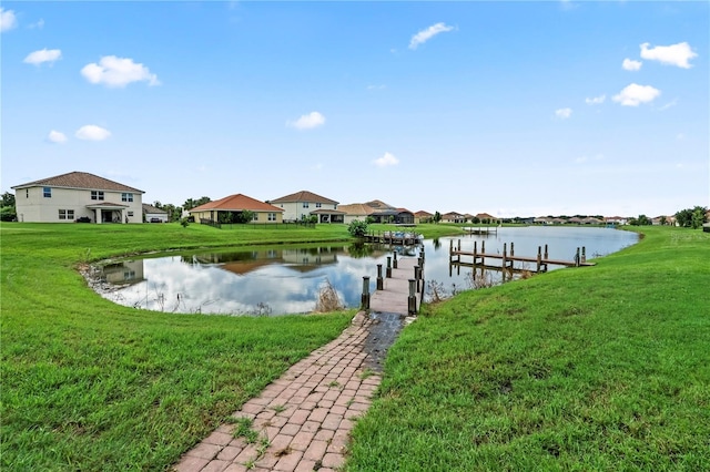 view of dock featuring a water view and a yard