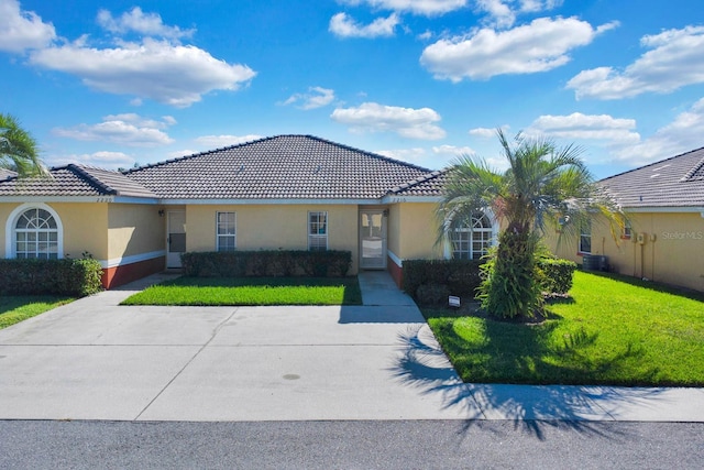 2216 Mystic Ring Loop, Poinciana, FL 34759 - mediterranean / spanish-style home with stucco siding, a front yard, and a tile roof