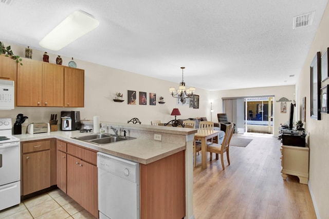 2216 Mystic Ring Loop, Poinciana, FL 34759 - kitchen with white appliances, a peninsula, open floor plan, a chandelier, and light countertops