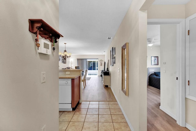 2216 Mystic Ring Loop, Poinciana, FL 34759 - hall featuring a chandelier and light wood-type flooring