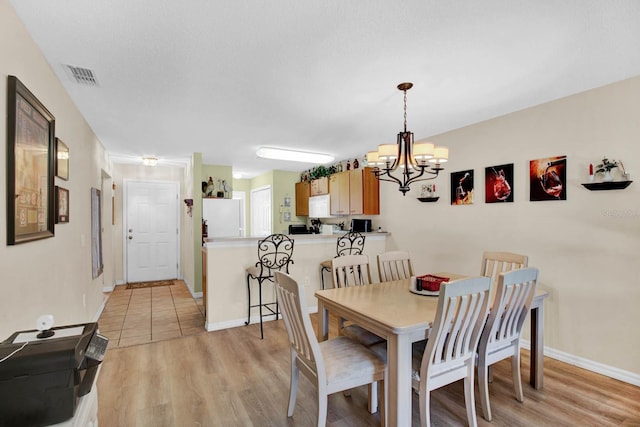 2216 Mystic Ring Loop, Poinciana, FL 34759 - dining area featuring a chandelier and light wood-type flooring