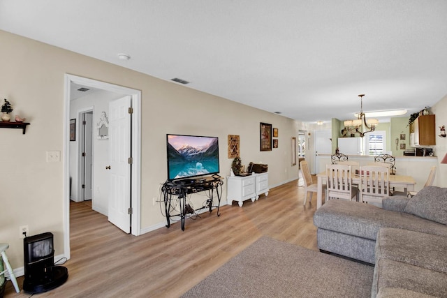 2216 Mystic Ring Loop, Poinciana, FL 34759 - living room featuring light wood-style flooring and a chandelier