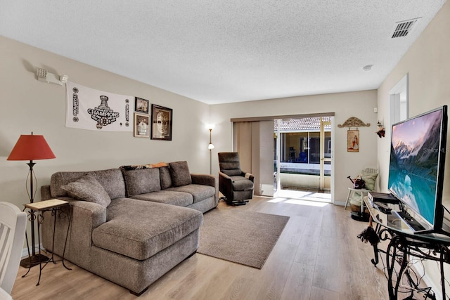 2216 Mystic Ring Loop, Poinciana, FL 34759 - living area with wood finished floors and a textured ceiling