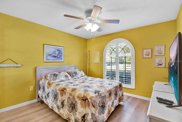 2216 Mystic Ring Loop, Poinciana, FL 34759 - bedroom with wood finished floors, a ceiling fan, and a textured ceiling