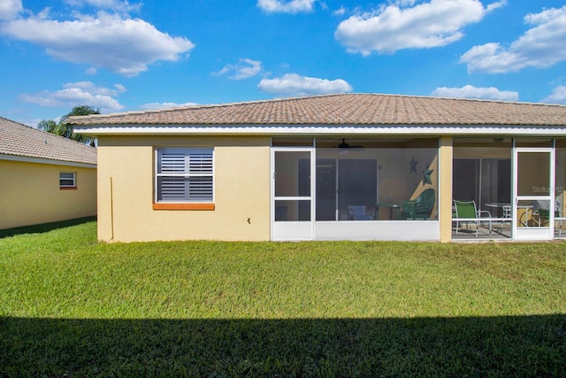 2216 Mystic Ring Loop, Poinciana, FL 34759 - rear view of house featuring a yard, a sunroom, and stucco siding