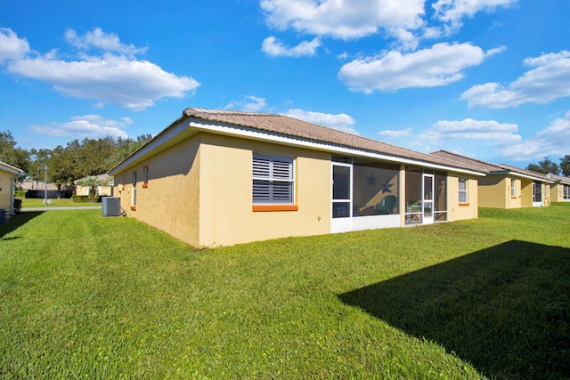 2216 Mystic Ring Loop, Poinciana, FL 34759 - rear view of property featuring stucco siding, a lawn, and a sunroom