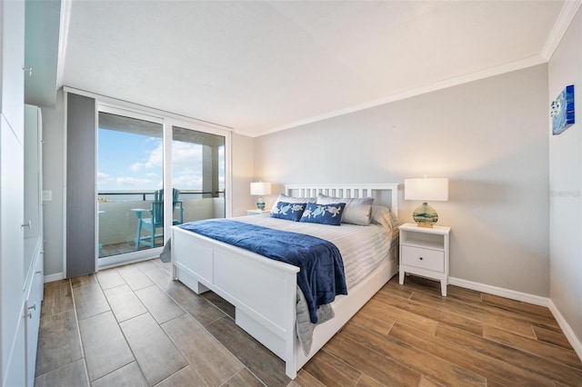 bedroom featuring access to exterior, hardwood / wood-style floors, expansive windows, and ornamental molding