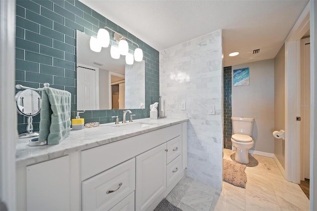 bathroom featuring vanity, tile walls, and toilet