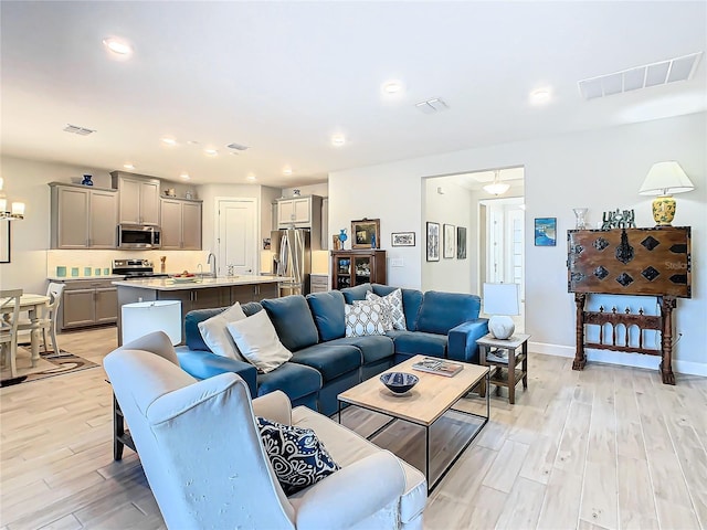 living room featuring sink and light wood-type flooring