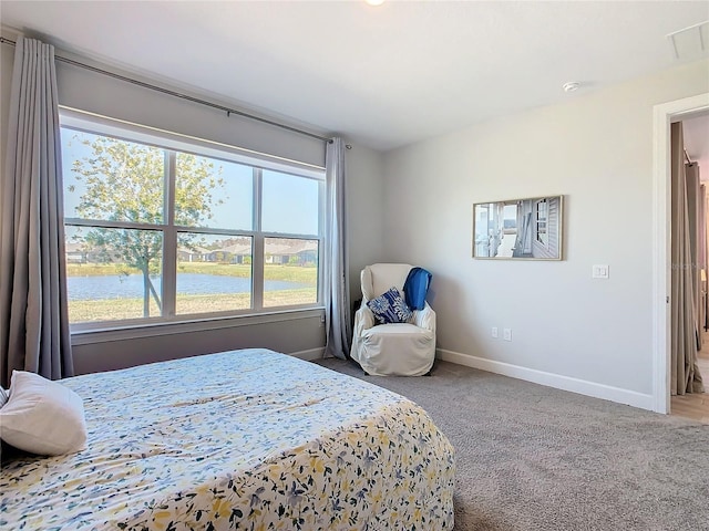 bedroom featuring a water view and carpet floors