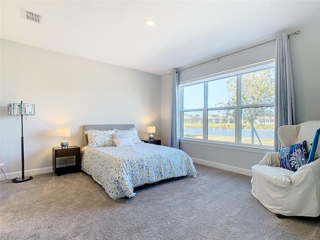 carpeted bedroom featuring a water view