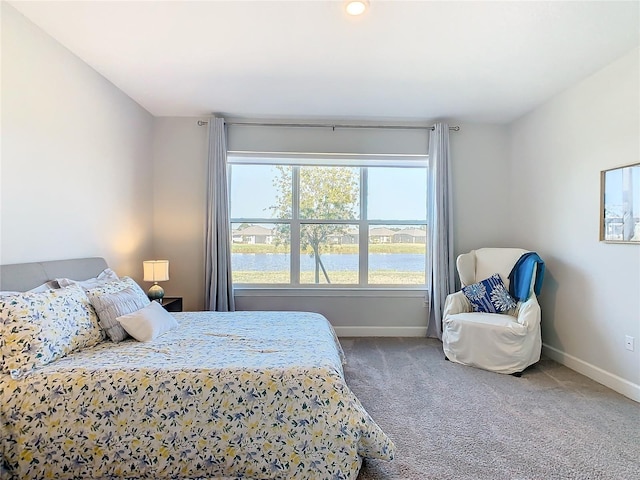 bedroom featuring carpet flooring and a water view