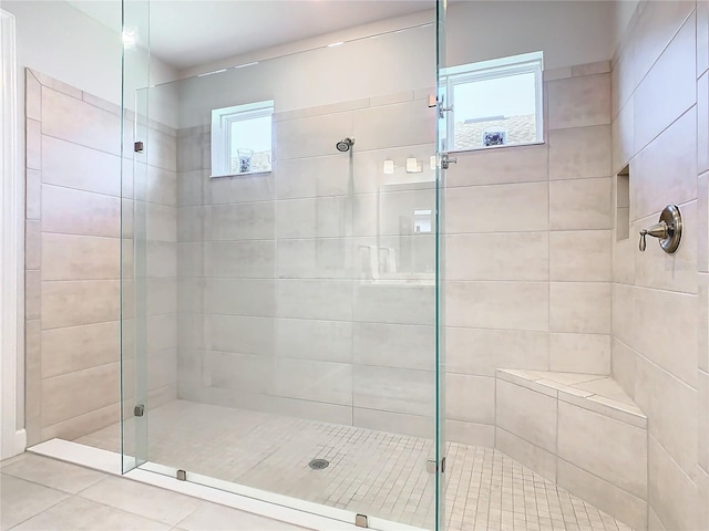 bathroom with a shower with door and a wealth of natural light