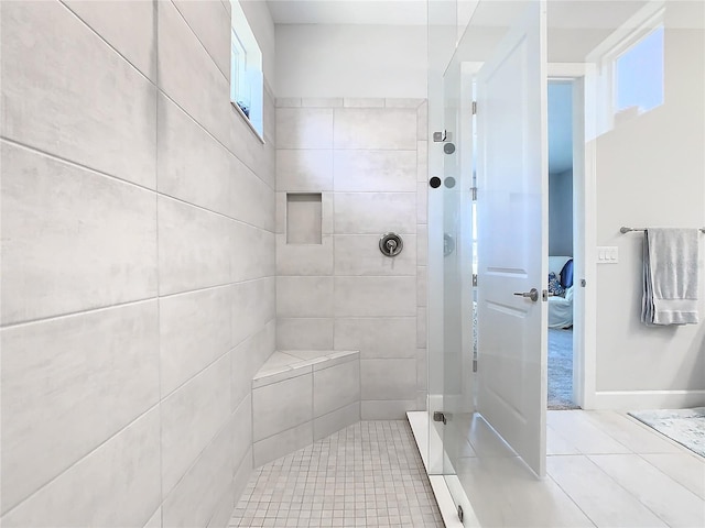 bathroom with tile patterned flooring and tiled shower