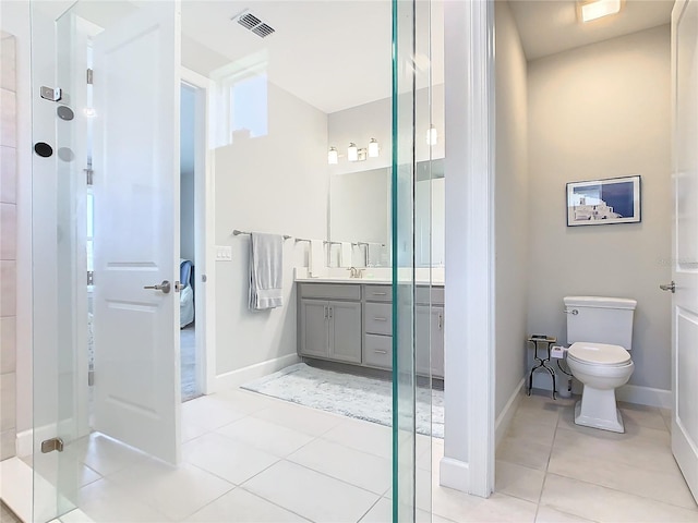 bathroom with toilet, tile patterned flooring, vanity, and walk in shower