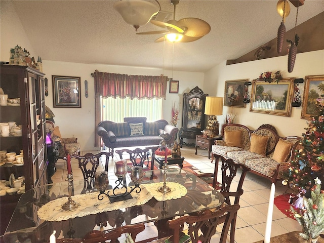 dining area with ceiling fan, light tile patterned flooring, a textured ceiling, and vaulted ceiling