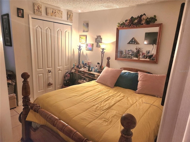 bedroom featuring a closet, light tile patterned floors, and a textured ceiling