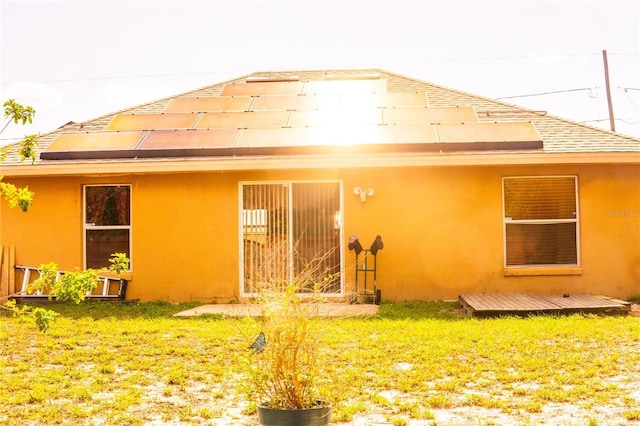 1053 Hemingway Dr, Deltona, FL 32725 - back of property with stucco siding, a yard, and roof with shingles