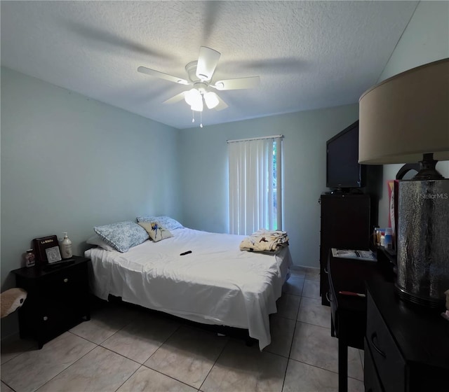 tiled bedroom featuring ceiling fan and a textured ceiling