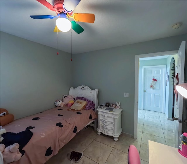 tiled bedroom featuring ceiling fan