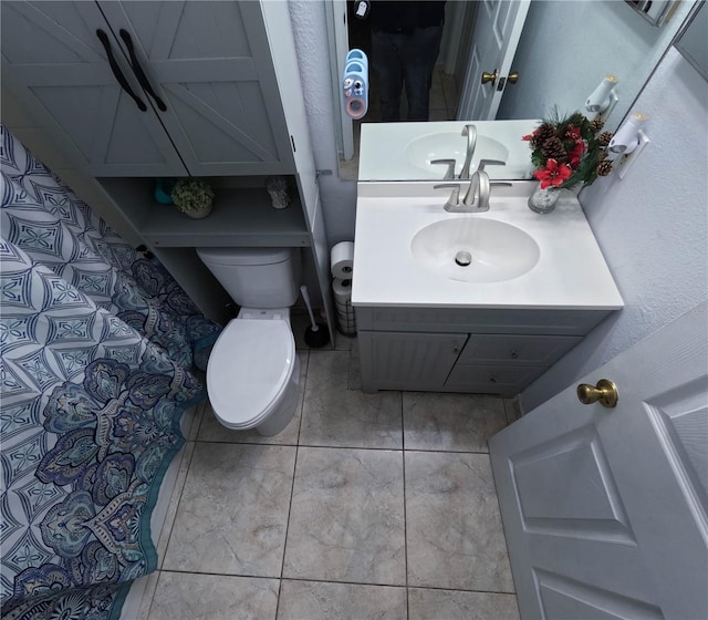 bathroom with tile patterned flooring, vanity, and toilet