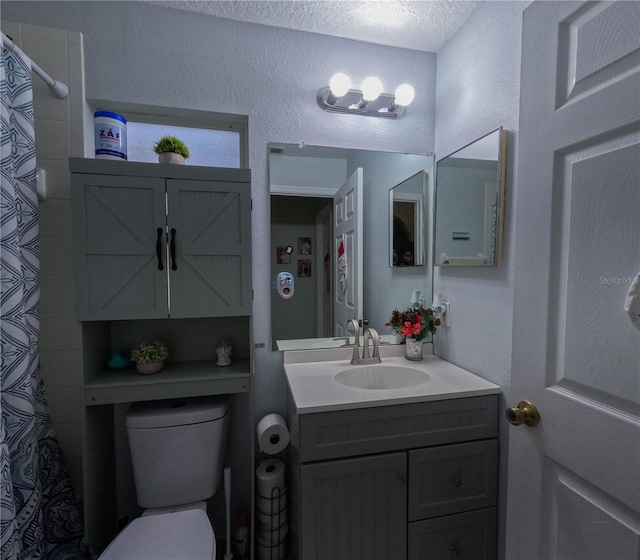 bathroom featuring vanity, a textured ceiling, and toilet