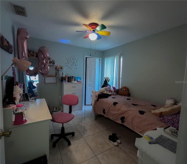 bedroom with ceiling fan and light tile patterned flooring