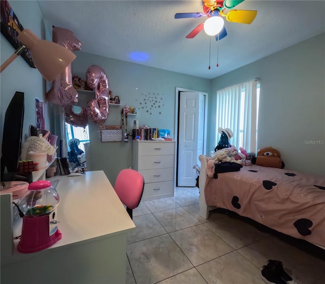 bedroom with ceiling fan and light tile patterned floors