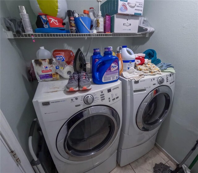 laundry area with washing machine and dryer and light tile patterned floors