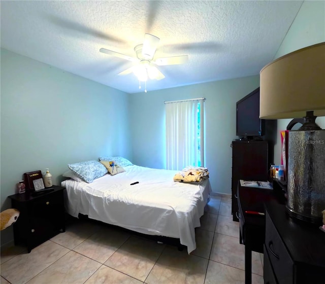 tiled bedroom with ceiling fan and a textured ceiling