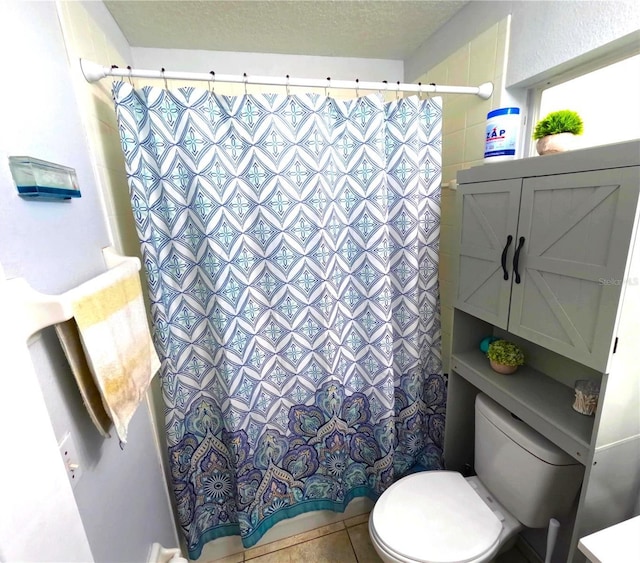 bathroom featuring a textured ceiling, toilet, tile patterned flooring, and a shower with shower curtain