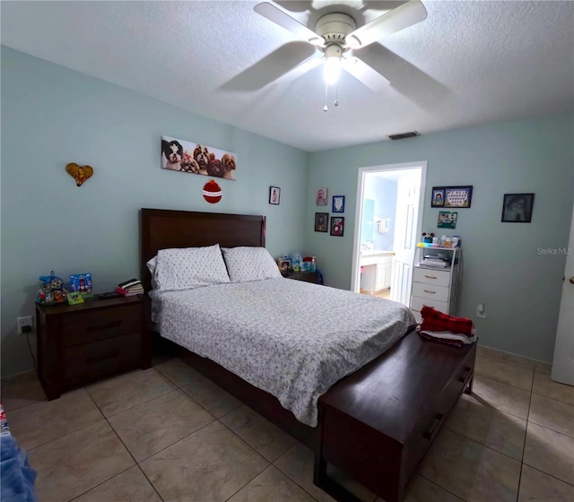 bedroom with light tile patterned floors, ceiling fan, and a textured ceiling