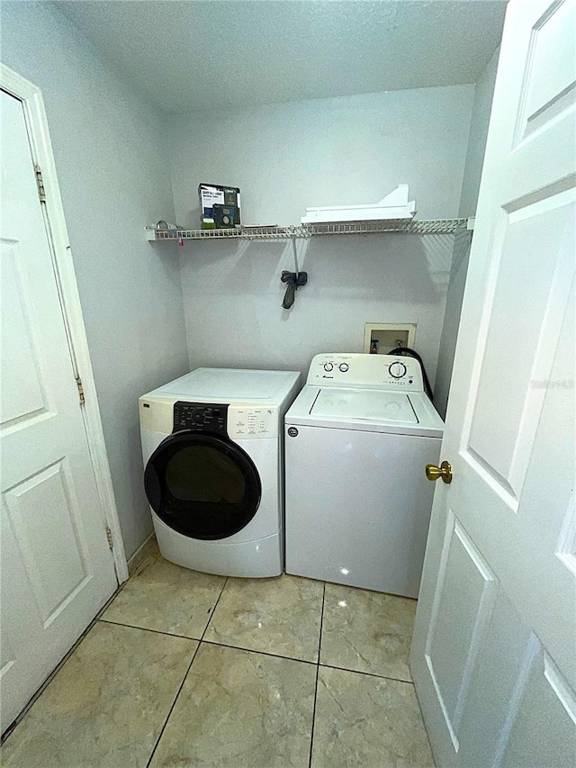 washroom with light tile patterned flooring and washing machine and dryer